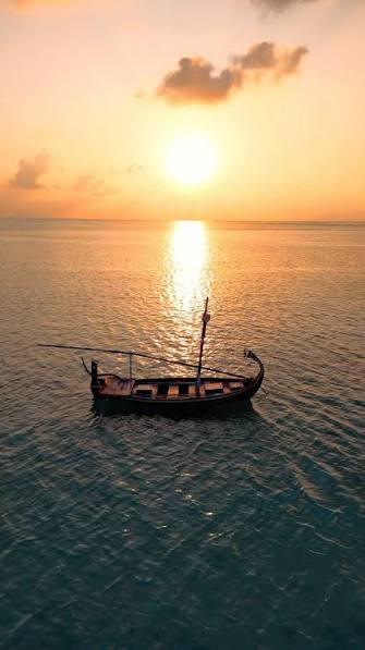 Traditional Maldivian dhoni boat at sunset
